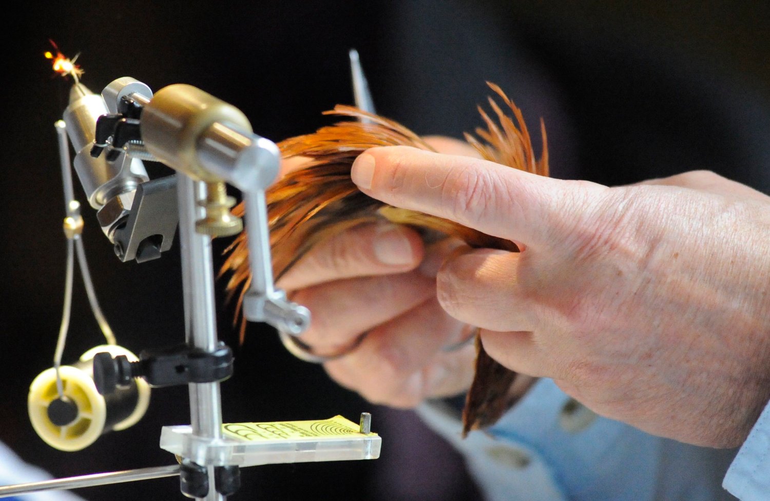 Creating a dry fly. Mike Stewart, a fly tier from North Granby, CT, concentrates on fashioning a fly from feathers and colored yarn.
